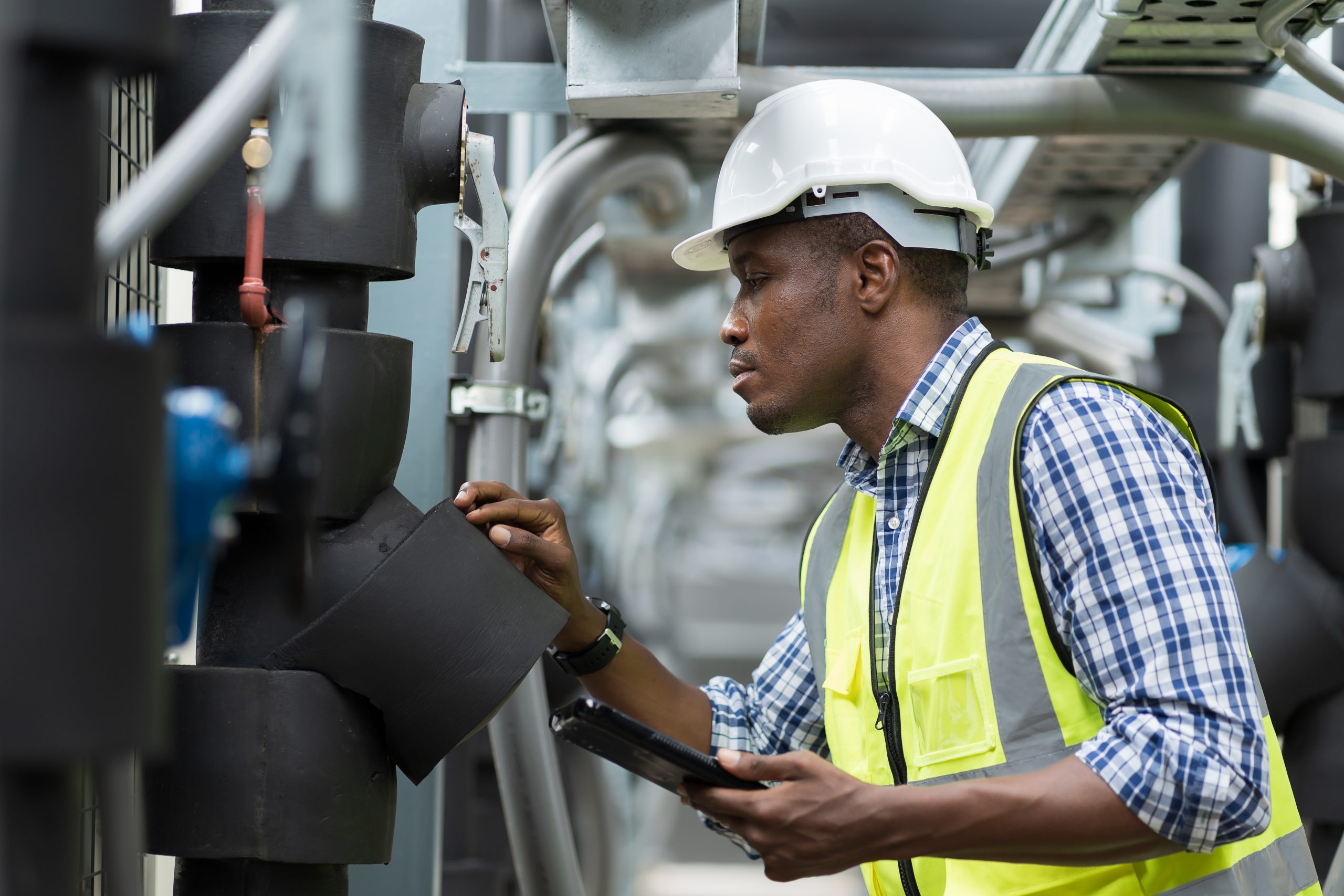Male Plumber Engineer Worker Work With Digital Tablet In Sewer Pipes Area At Construction Site. African American Male Engineer Worker Check Or Maintenance Sewer Pipe Network System At Construction Sit