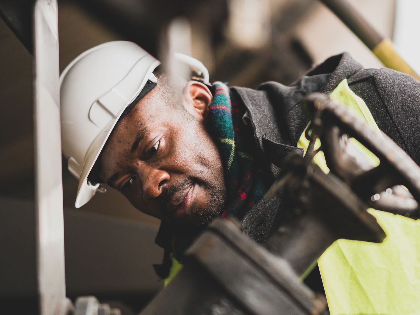 Closeup Of A Man Working On Site Wearing A Hard Hat And Safety Vest