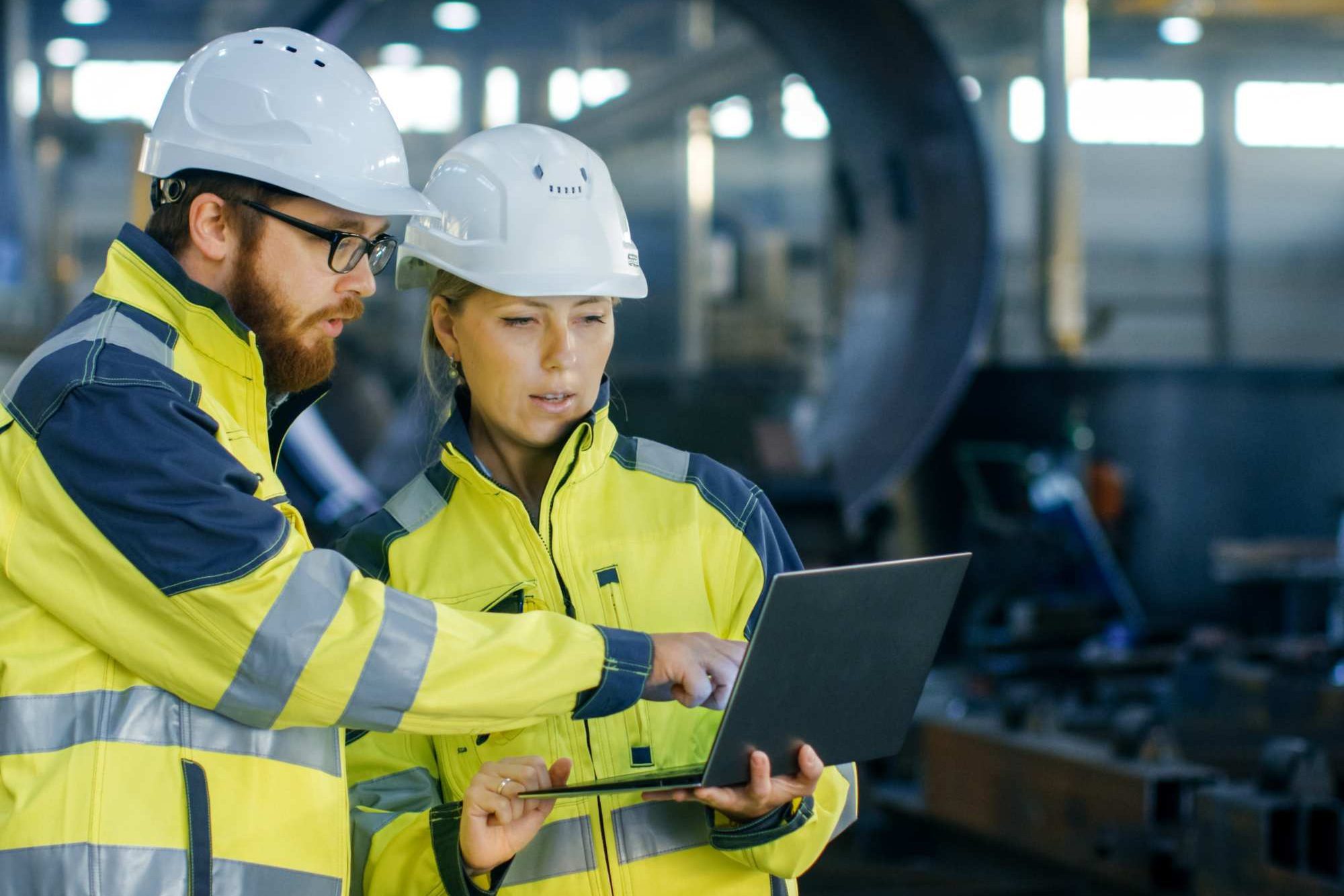 Two People In Yellow Hi Vis Jackets Looking At Laptop Aspect Ratio 1200 800