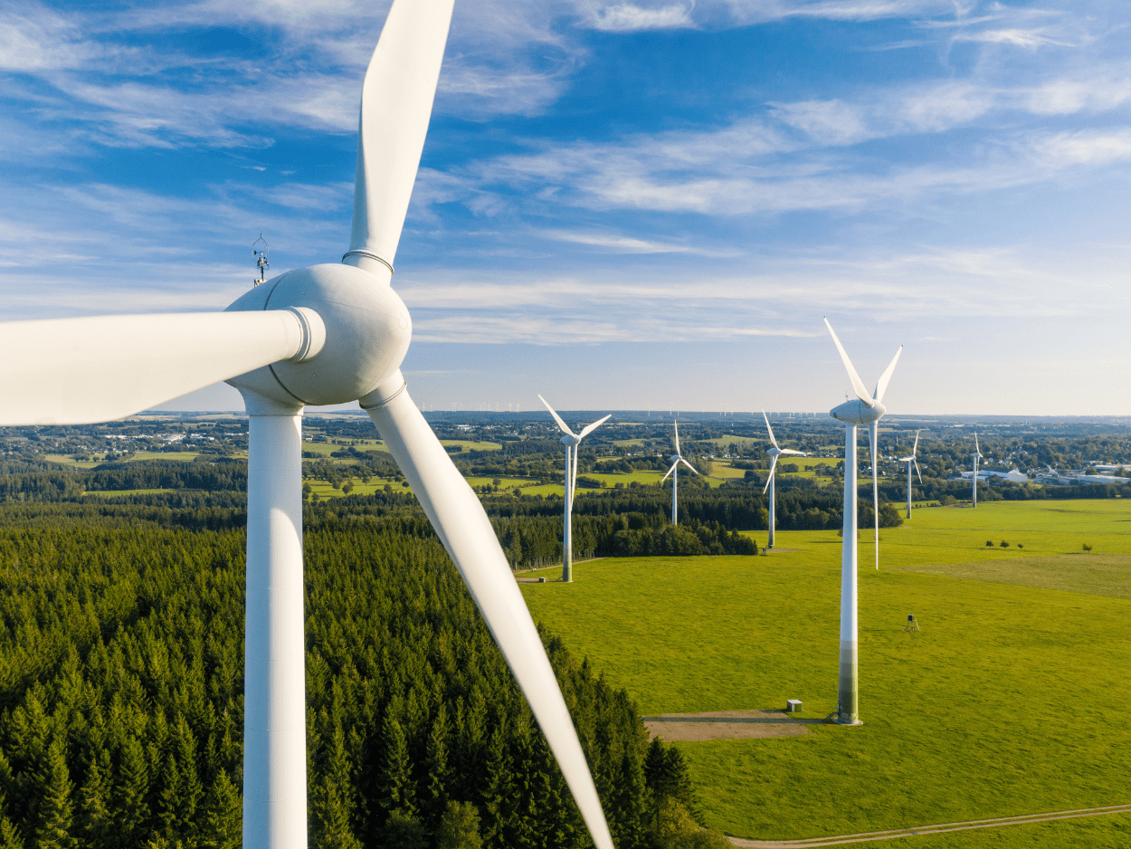 Wind Turbines In A Green Field With Blue Sky