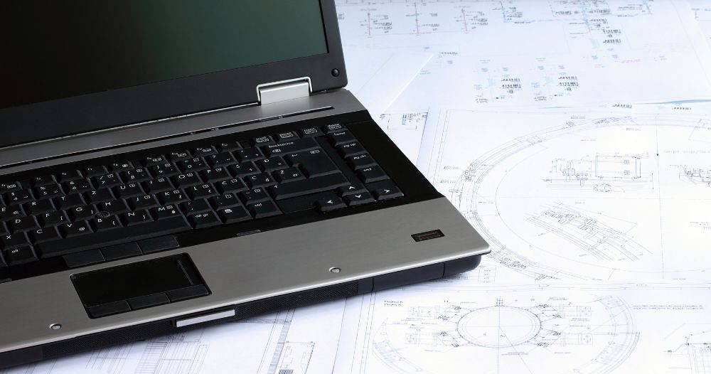 A Laptop Is Sitting On Top Of Blueprints Aspect Ratio 760 400