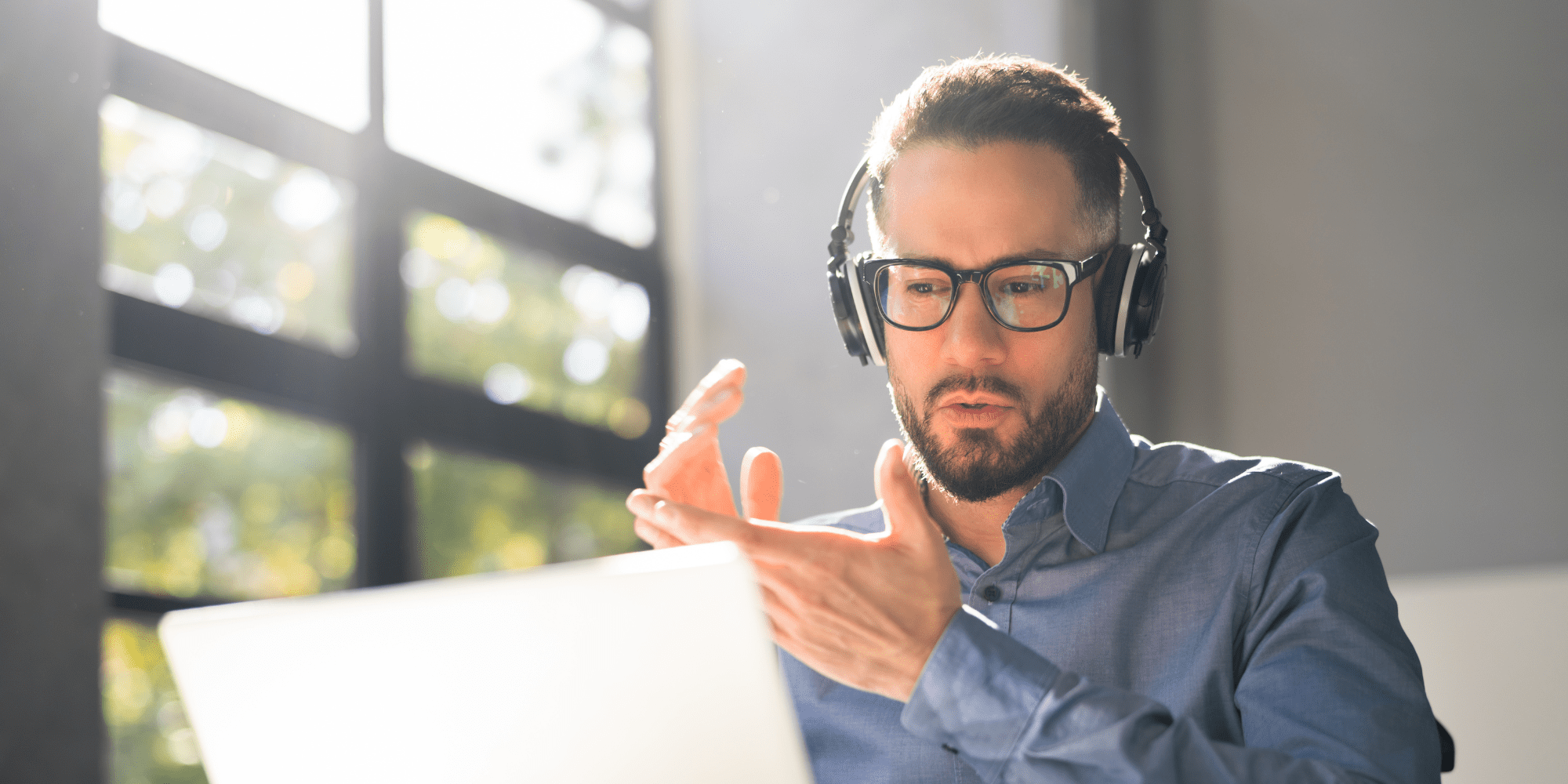 Man With Glasses And Headphones Sitting In Front Of A Laptop 1 Aspect Ratio 1160 580